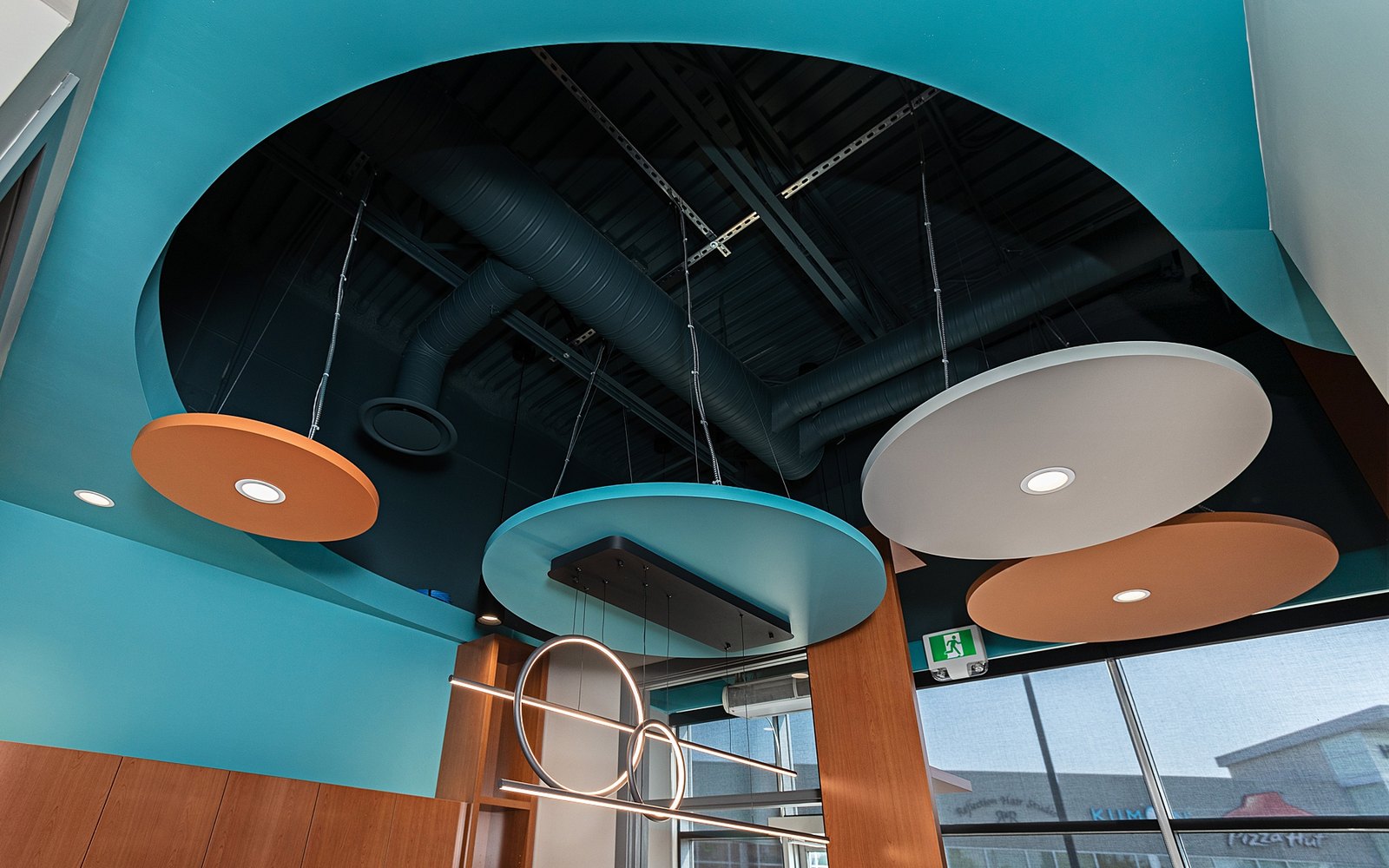 The open ceiling and teal feature wall above reception at Trust Care Physiotherapy