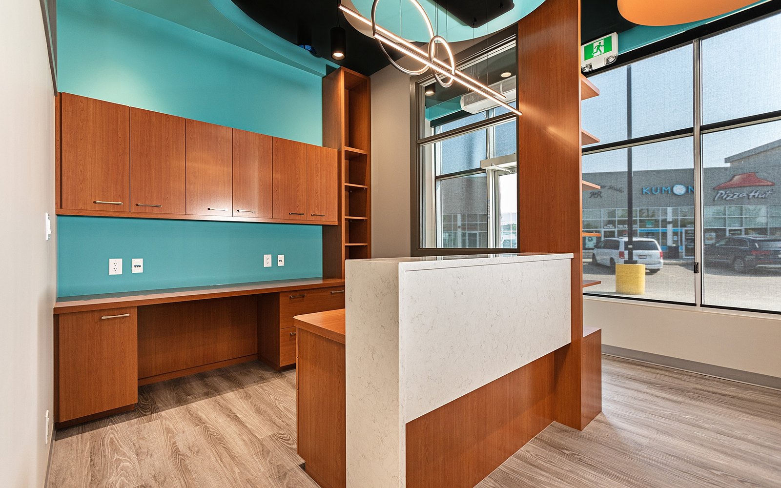 The reception desk and front office at Trust Care Physiotherapy, with the clinic teal feature wall