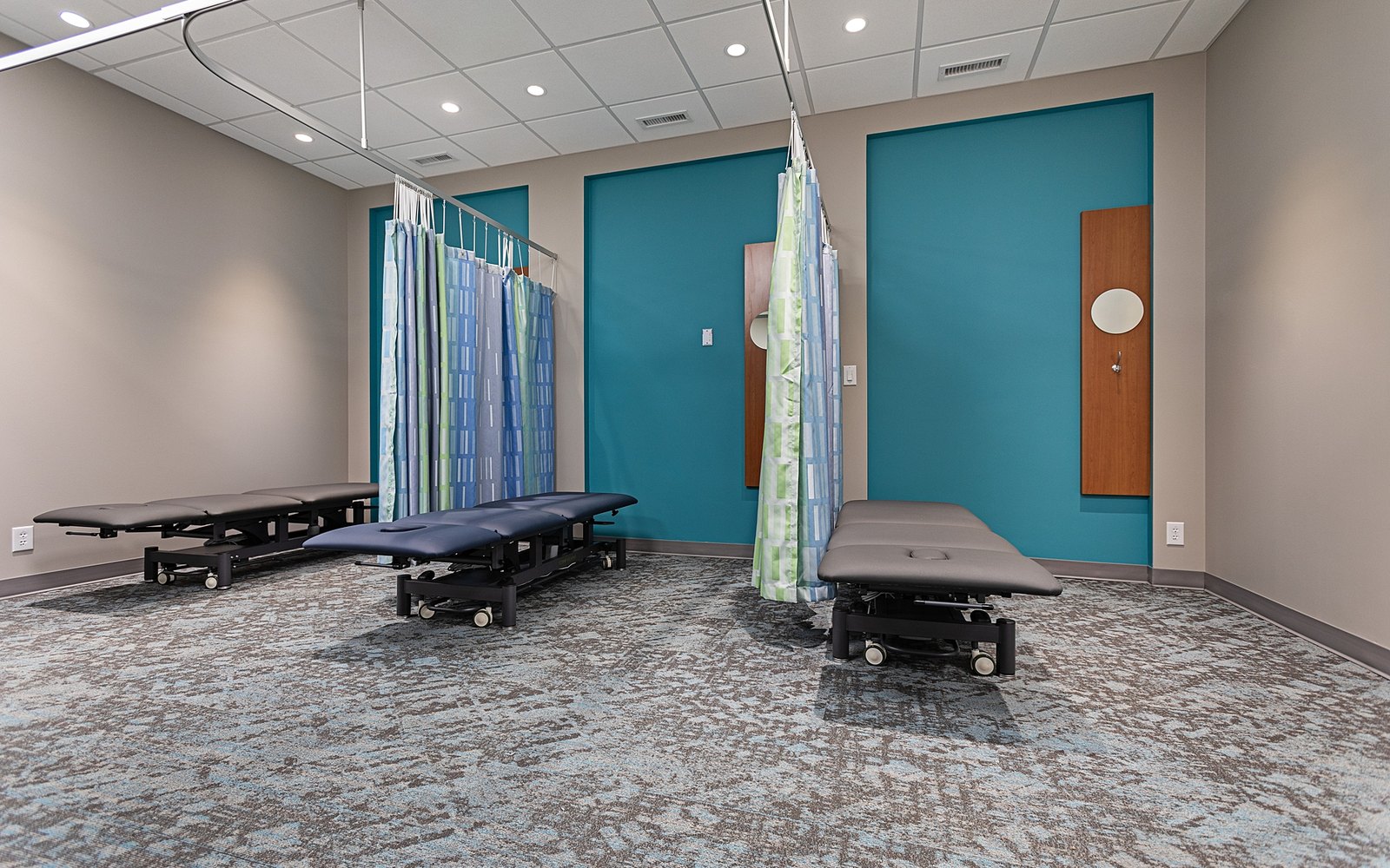Treatment plinths and privacy curtains in the clinical area at Trust Care Physiotherapy