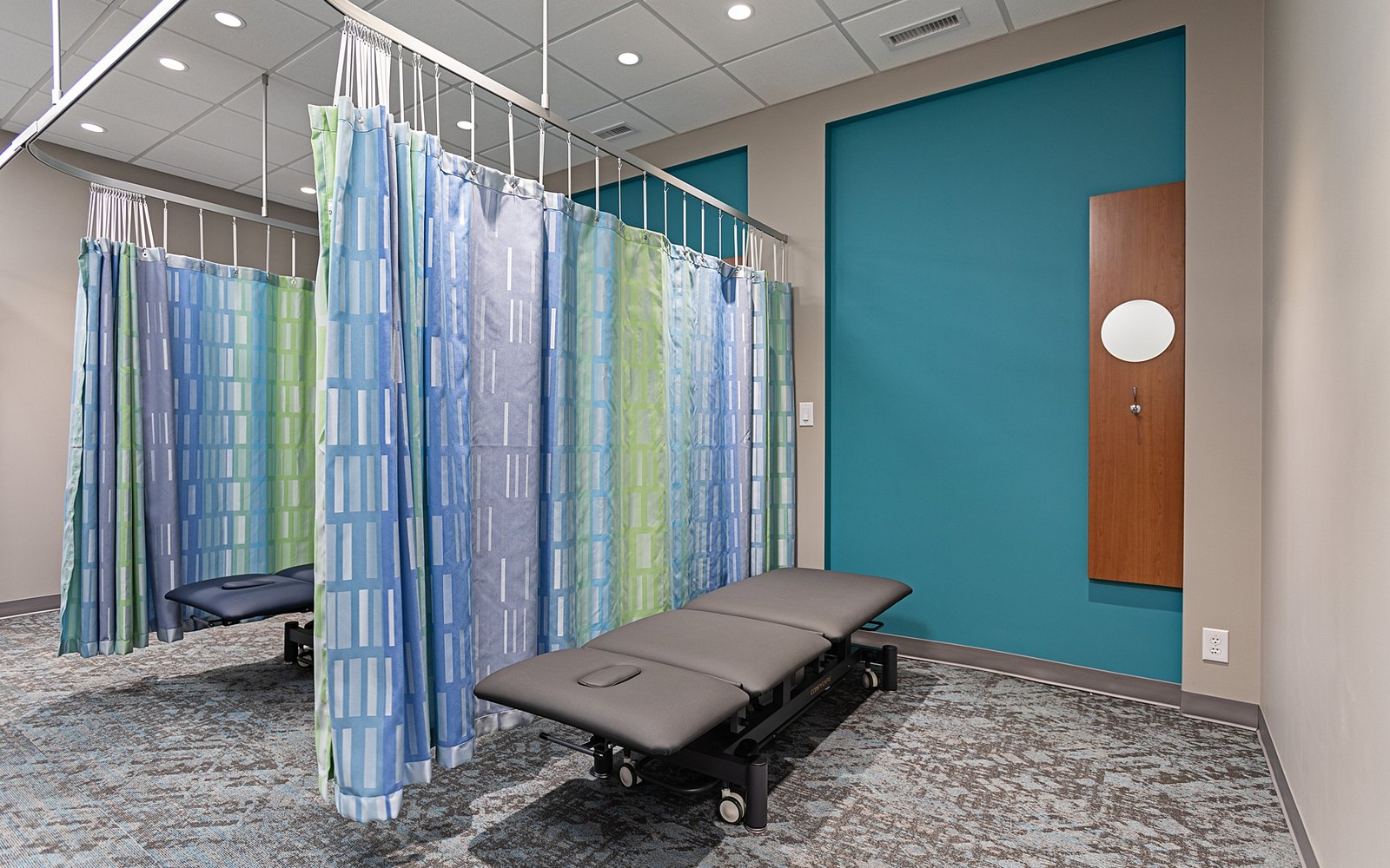 A curtained treatment bay with a plinth at Trust Care Physiotherapy